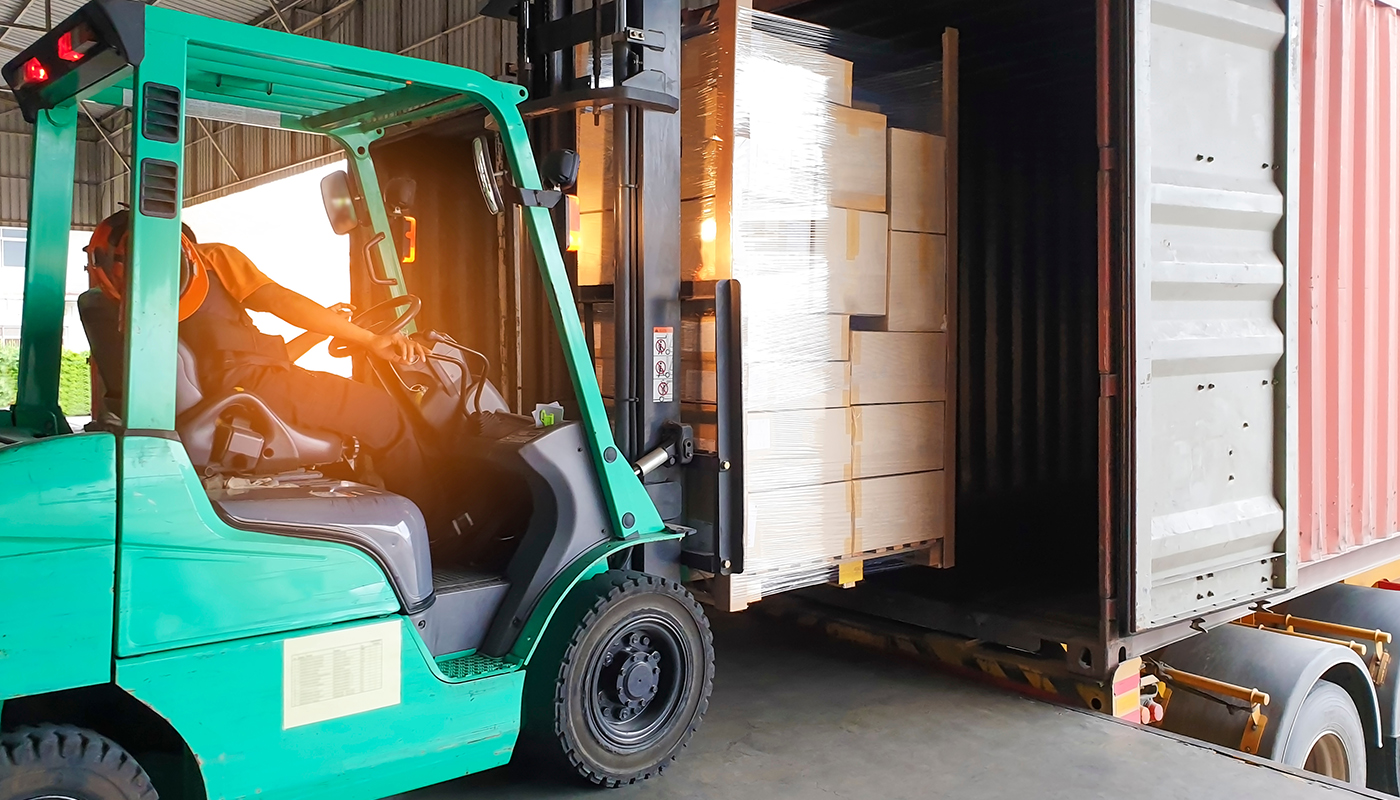forklift loading boxes into the back of a semi truck - shippers working
