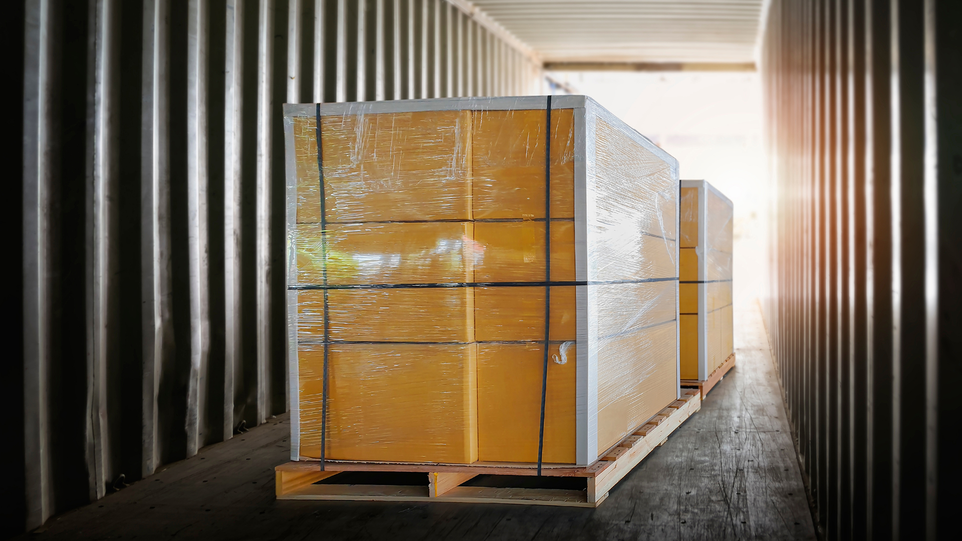 Shrink-wrapped boxes on pallets in the back of a semi truck about to be shipped