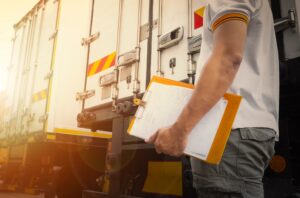 A driver holding documents that detail trucking rates