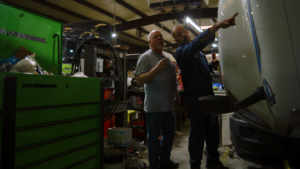 Mid-KY Trucking owner Ricky Brahm and his nephew, Paul, inspecting a truck while discussing business relationships.