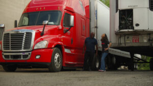 Spot employee, Jada Wallace, and carrier Randolph James, in front of semi trucks